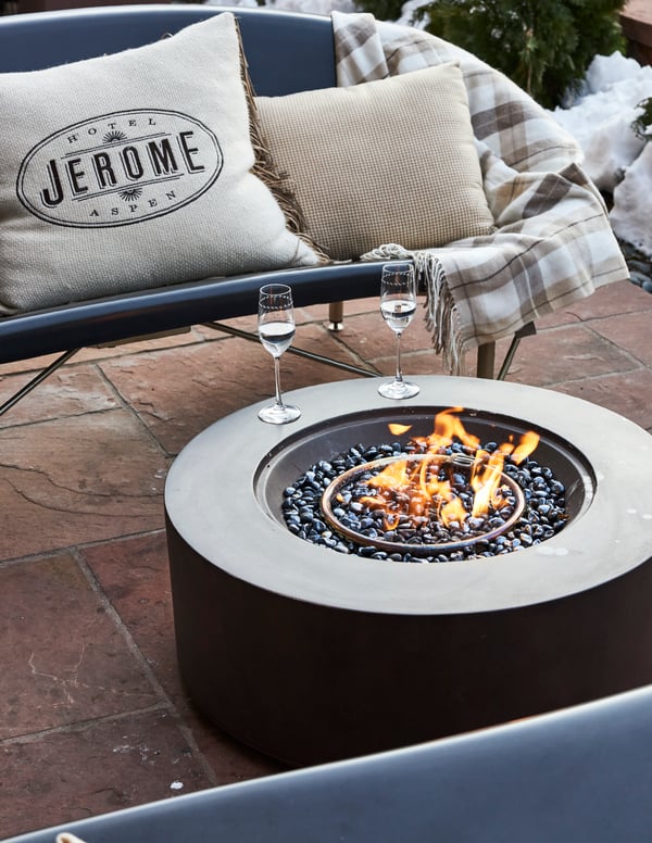 Heated Helios lounges and a firepit on the patio at Hotel Jerome in Aspen, CO